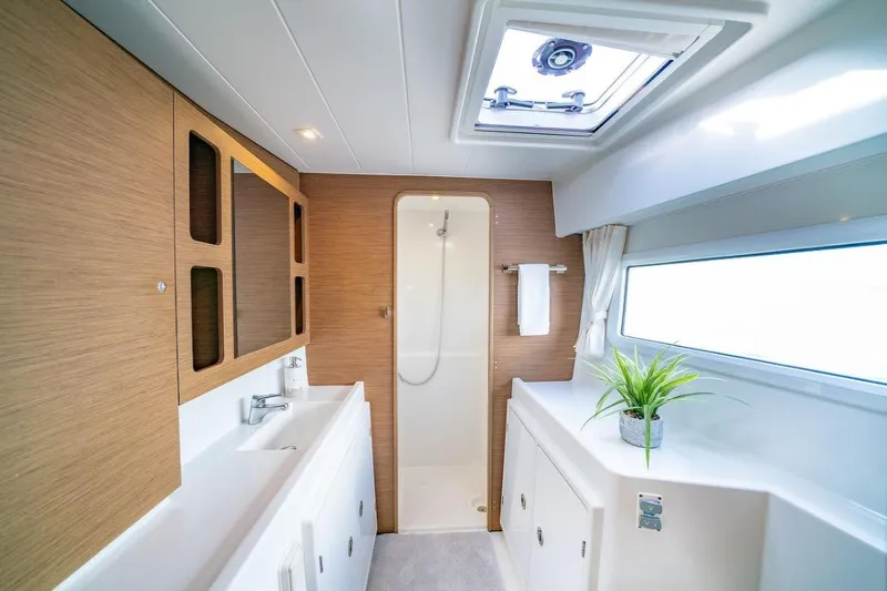 Hopena Yacht Photos Pics Luxurious bathroom interior of 2018 Lagoon 42 catamaran with modern fixtures and natural light.
