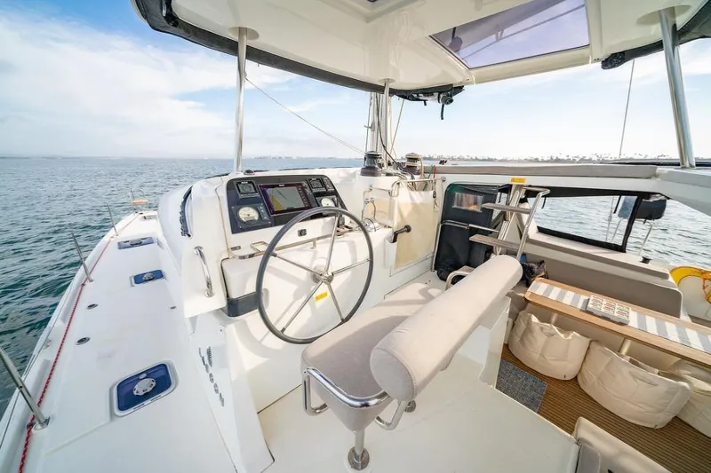 Hopena Yacht Photos Pics 2018 Lagoon 42 catamaran cockpit with steering wheel, navigation instruments, and ocean view.