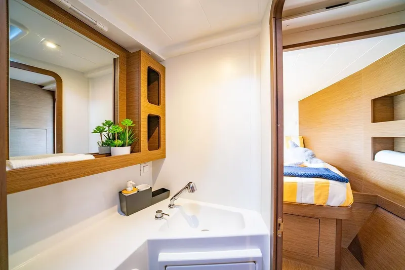 Hopena Yacht Photos Pics Luxurious interior of 2019 Lagoon 42 yacht featuring modern bathroom and cozy bedroom.