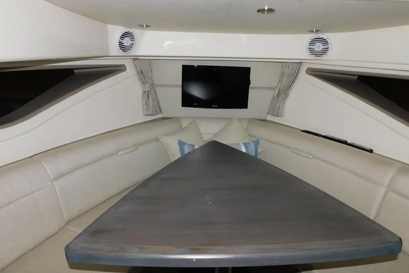 Not Guilty Yacht Photos Pics Interior of 2018 Sea Ray Sundancer 320 with seating, table, and TV.