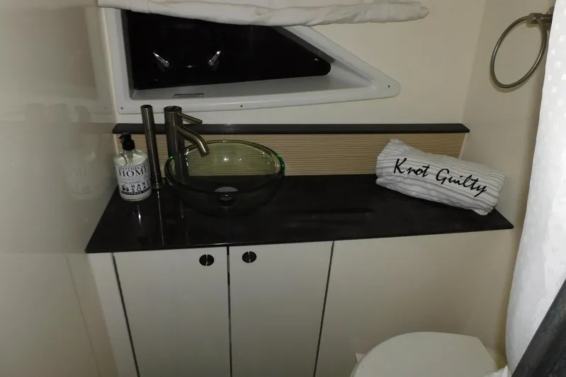 Not Guilty Yacht Photos Pics 2018 Sea Ray Sundancer 320 bathroom with modern sink, faucet, and "Knot Guilty" pillow.