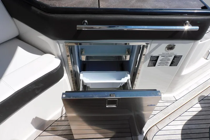 Not Guilty Yacht Photos Pics Open refrigerator on 2018 Sea Ray Sundancer 320 yacht, showcasing interior storage.