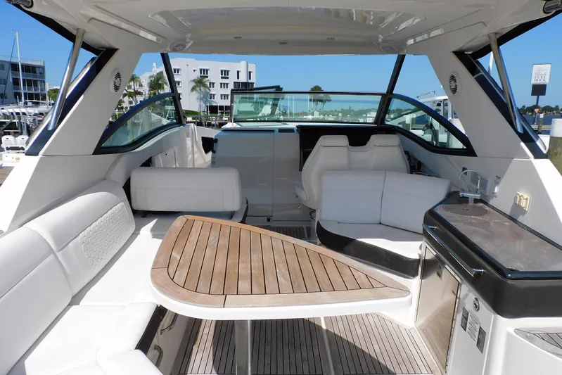 Not Guilty Yacht Photos Pics 2018 Sea Ray Sundancer 320 interior with sleek seating and wooden table.