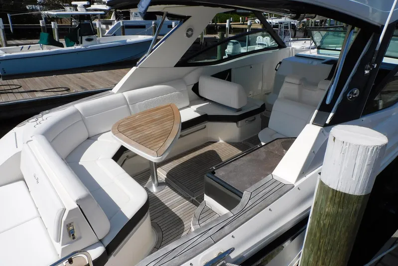 Not Guilty Yacht Photos Pics 2018 Sea Ray Sundancer 320 boat interior with seating and wooden table.