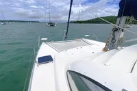 2009 Leopard 40 catamaran sailing on calm waters with lush green shoreline.