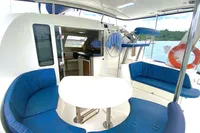 2009 Leopard 40 catamaran interior with blue seating, white table, and ocean view.