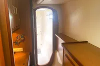Interior of 2009 Leopard 40 yacht, featuring wooden cabinetry and a doorway to the bathroom.
