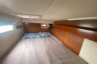 Cozy cabin interior of 2009 Leopard 40 catamaran with bed and porthole windows.