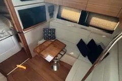  Yacht Photos Pics Interior of 2022 Boston Whaler 405 Conquest with cozy seating and wooden table.