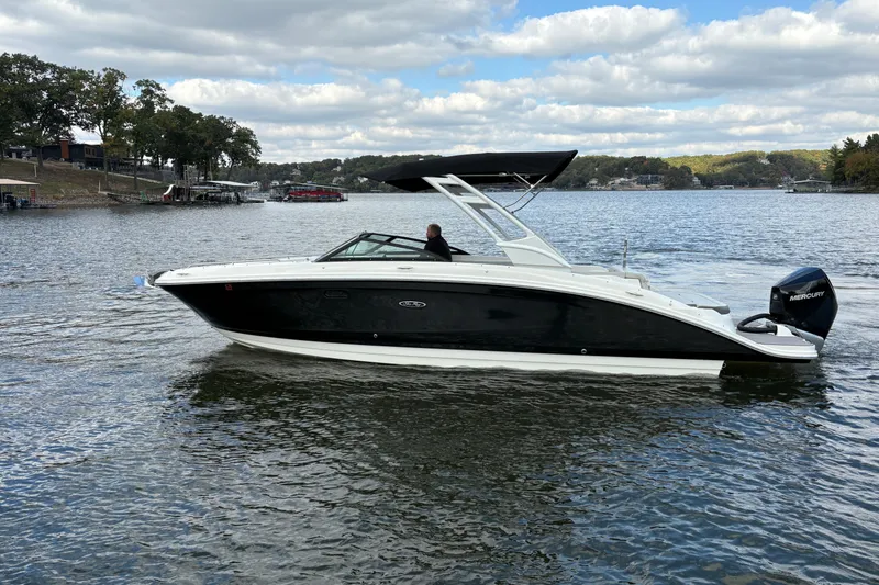  Yacht Photos Pics 2022 Sea Ray SDX 270 Outboard boat cruising on a scenic lake under a cloudy sky.