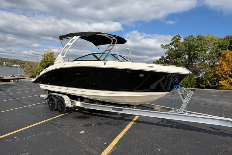  Yacht Photos Pics 2022 Sea Ray SDX 270 Outboard boat on trailer, parked near a lake under cloudy sky.