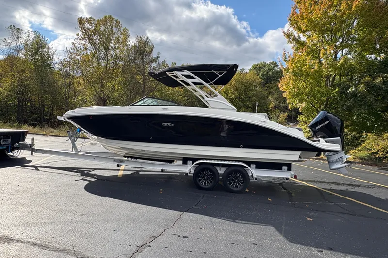  Yacht Photos Pics 2022 Sea Ray SDX 270 Outboard boat on trailer in parking lot, surrounded by trees.
