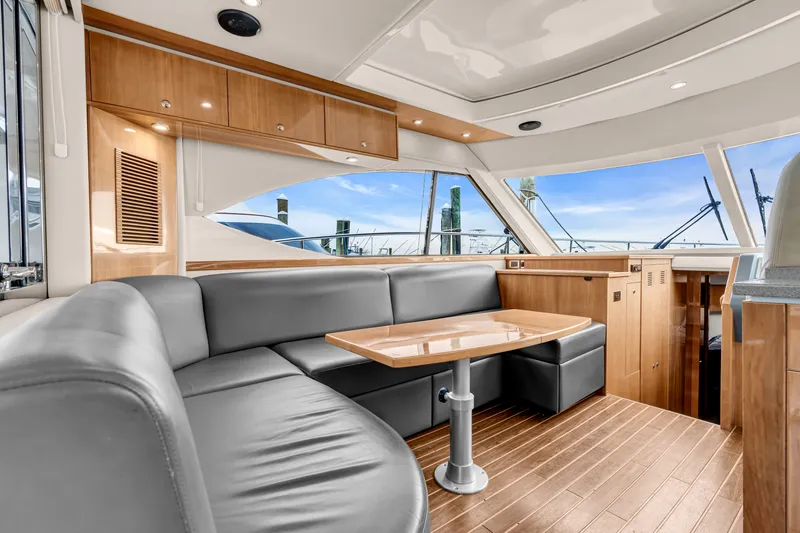 Ayeroller Yacht Photos Pics Interior of a 2014 Riviera 44 Sport Yacht with leather sofa and wooden table.