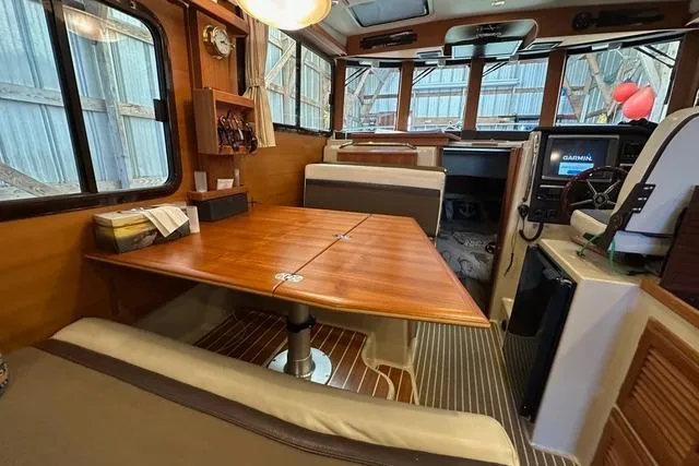 Glasgow Ranger Yacht Photos Pics 2014 Ranger Tugs R-31 interior with wooden table, seating, and navigation equipment.