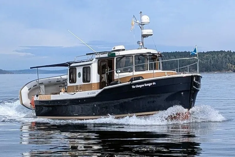 Glasgow Ranger Yacht Photos Pics 2014 Ranger Tugs R-31 cruising on calm waters with scenic background.