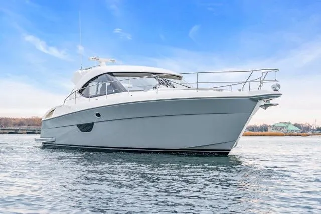 Ayeroller Yacht Photos Pics 2014 Riviera 4400 Sport Yacht cruising on calm waters under a clear blue sky.