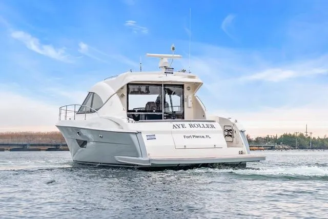 Ayeroller Yacht Photos Pics 2014 Riviera 4400 Sport Yacht cruising on water under a clear blue sky.