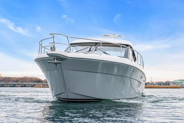 Ayeroller Yacht Photos Pics 2014 Riviera 4400 Sport Yacht cruising on calm waters under a clear blue sky.