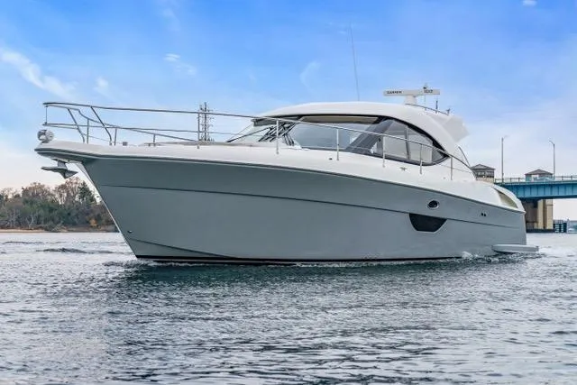 Ayeroller Yacht Photos Pics 2014 Riviera 4400 Sport Yacht cruising on calm waters under a clear blue sky.