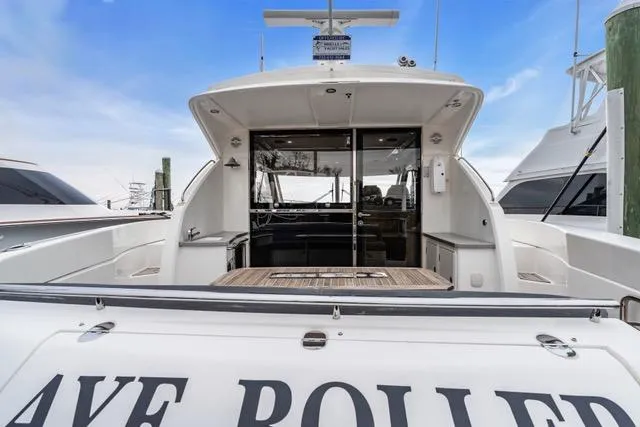 Ayeroller Yacht Photos Pics 2014 Riviera 4400 Sport Yacht docked, rear view with open cockpit and clear sky.