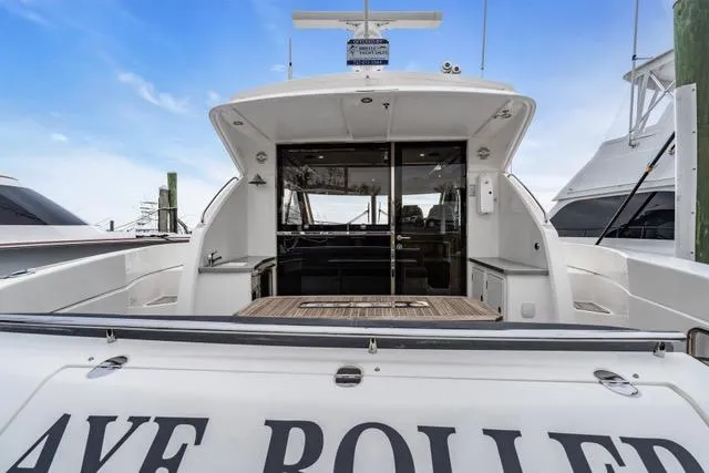 Ayeroller Yacht Photos Pics 2014 Riviera 4400 Sport Yacht, rear view, docked with open cockpit and clear sky.