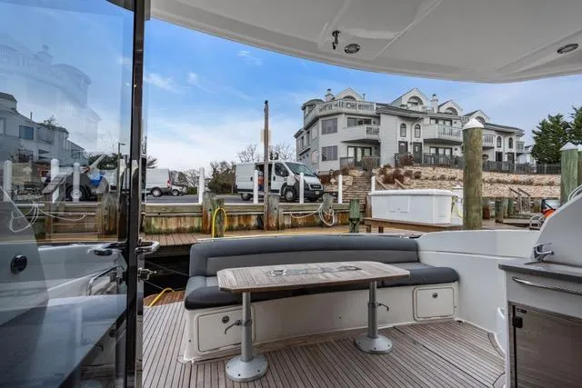 Ayeroller Yacht Photos Pics 2014 Riviera 4400 Sport Yacht docked, featuring outdoor seating and scenic waterfront view.