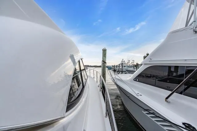 Ayeroller Yacht Photos Pics 2014 Riviera 4400 Sport Yacht docked beside another yacht under a clear blue sky.