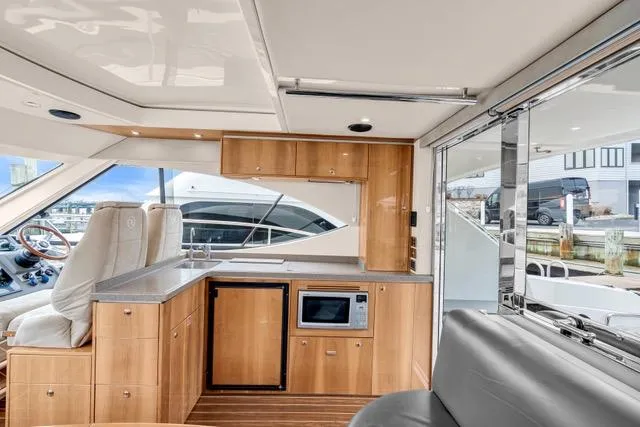 Ayeroller Yacht Photos Pics Interior of 2014 Riviera 4400 Sport Yacht with modern kitchen and seating area.