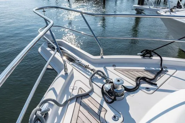 Ayeroller Yacht Photos Pics 2014 Riviera 4400 Sport Yacht bow with ropes and winch, reflecting sunlight on water.