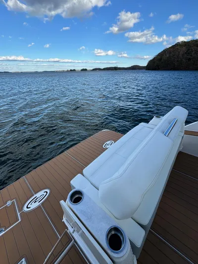 Nightingale Yacht Photos Pics 2023 Regal 36 Grande Coupe boat on serene lake with blue sky.