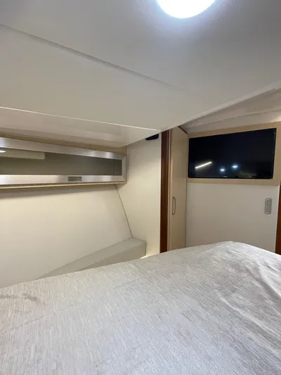Nightingale Yacht Photos Pics 2023 Regal 36 Grande Coupe interior cabin with bed and TV.