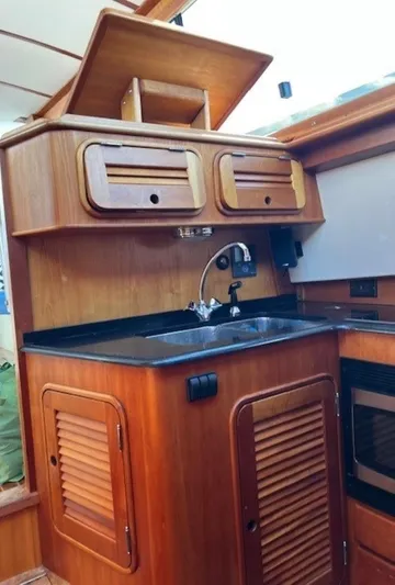 Fine Time Yacht Photos Pics 2002 Hinckley Talaria 44 FB yacht kitchen with wooden cabinetry and sink.
