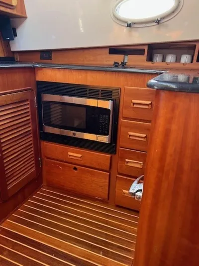 Fine Time Yacht Photos Pics Hinckley Talaria 44 FB 2002 yacht kitchen with microwave and wooden cabinetry.