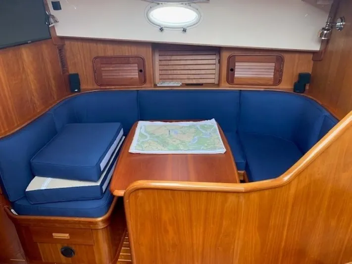 Fine Time Yacht Photos Pics Cozy interior of 2002 Hinckley Talaria 44 FB with blue seating and wooden table.