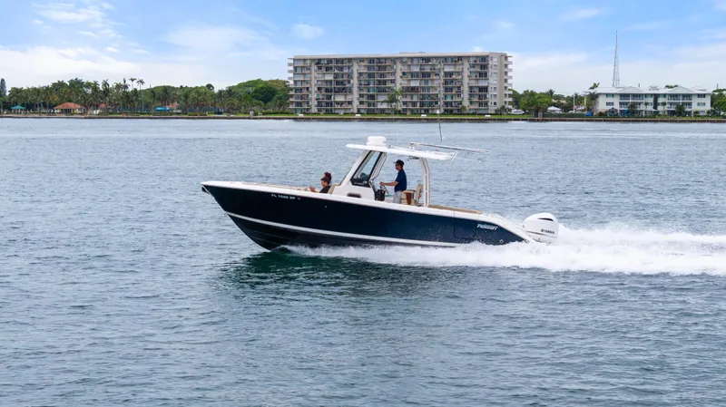 Little Perspective Yacht Photos Pics 2019 Pursuit S 288 Sport boat cruising on water near coastal buildings.
