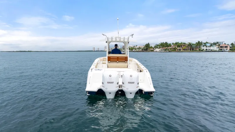 Little Perspective Yacht Photos Pics 2019 Pursuit S 288 Sport boat on calm water, with coastal homes in the background.