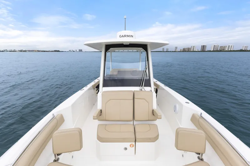 Little Perspective Yacht Photos Pics 2019 Pursuit S 288 Sport boat on calm water with city skyline in background.