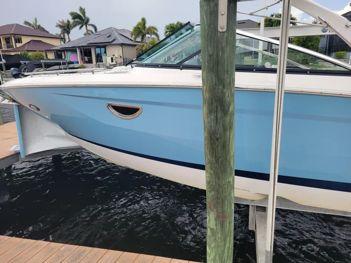  Yacht Photos Pics 2020 Regal 29 OBX boat in light blue, docked near waterfront homes.