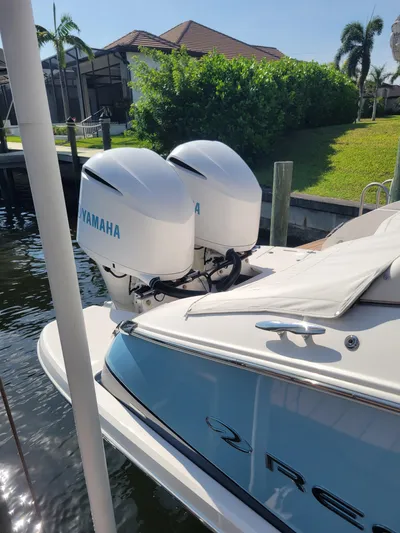  Yacht Photos Pics 2020 Regal 29 OBX boat with twin Yamaha outboard engines docked by lush greenery.