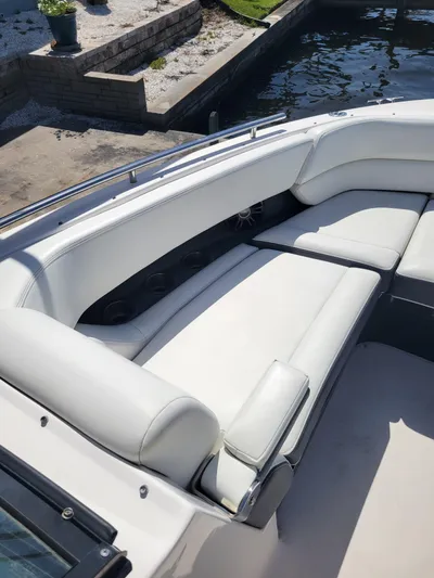  Yacht Photos Pics 2020 Regal 29 OBX boat with white leather seating, docked by a stone wall.