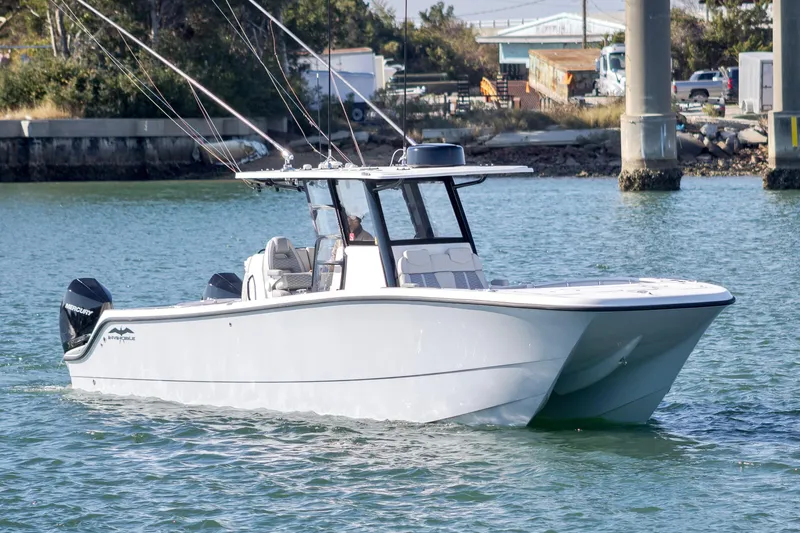  Yacht Photos Pics 2022 Invincible 33 Catamaran cruising on water, featuring sleek design and dual engines.