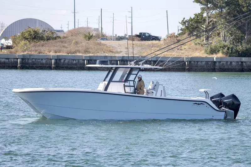  Yacht Photos Pics 2022 Invincible 33 Catamaran cruising on a calm waterway.