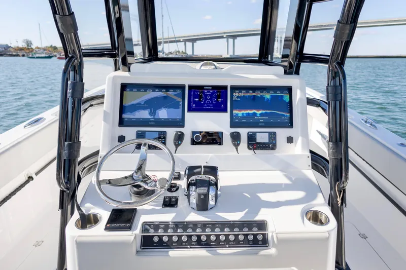  Yacht Photos Pics 2022 Invincible 33 Catamaran dashboard with dual screens and steering wheel on open water.