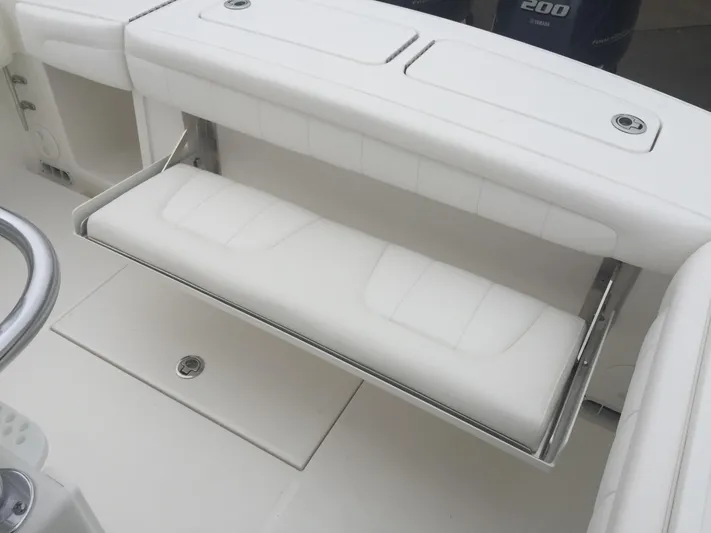  Yacht Photos Pics 2017 Regulator 25 boat with white cushioned seating and storage compartment.