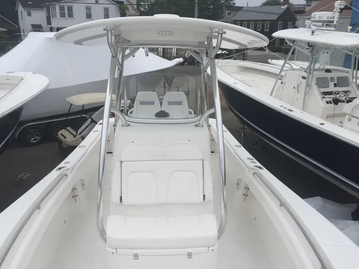  Yacht Photos Pics 2017 Regulator 25 boat with T-top and seating, docked among other boats.