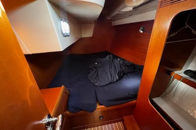 Eagles Wings Yacht Photos Pics Cozy cabin interior of 2003 Grand Soleil 44 sailboat with wooden finish and bedding.