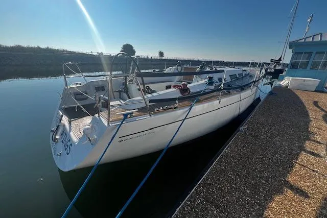 Eagles Wings Yacht Photos Pics 2003 Grand Soleil 44 yacht docked in a sunny marina, reflecting on calm water.