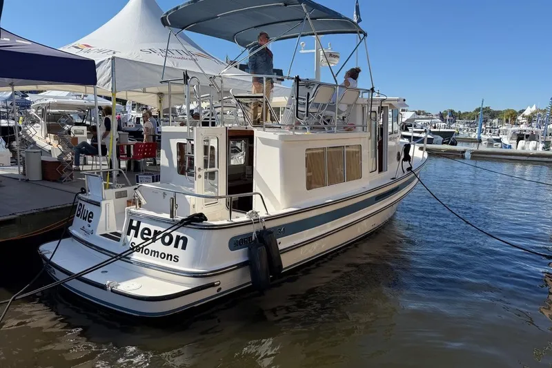 Blue Heron Yacht Photos Pics 2015 Nordic Tug 34 docked at marina, featuring upper deck and canopy.