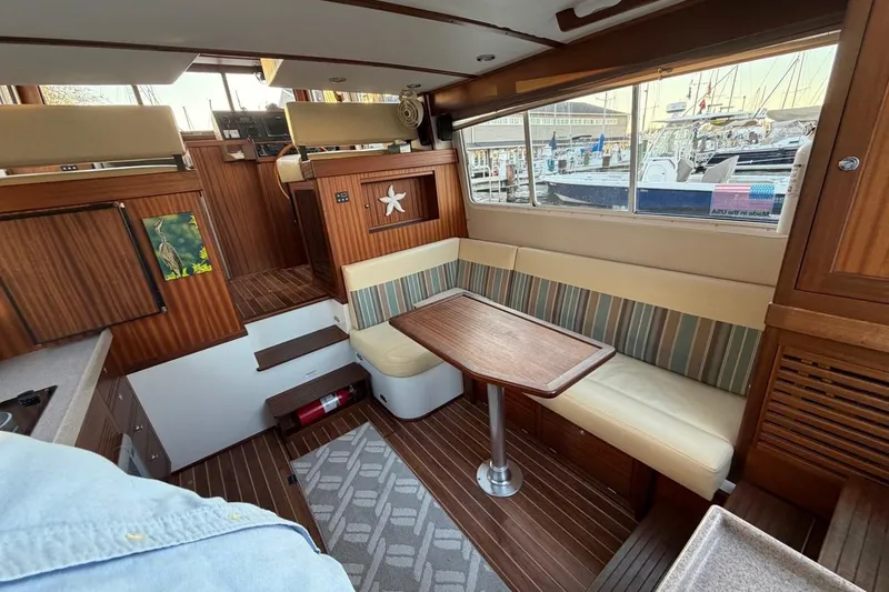 Blue Heron Yacht Photos Pics Interior of 2015 Nordic Tug 34 with wooden finishes and striped seating.