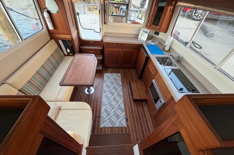 Blue Heron Yacht Photos Pics Interior of 2015 Nordic Tug 34, featuring a cozy seating area and compact kitchen.